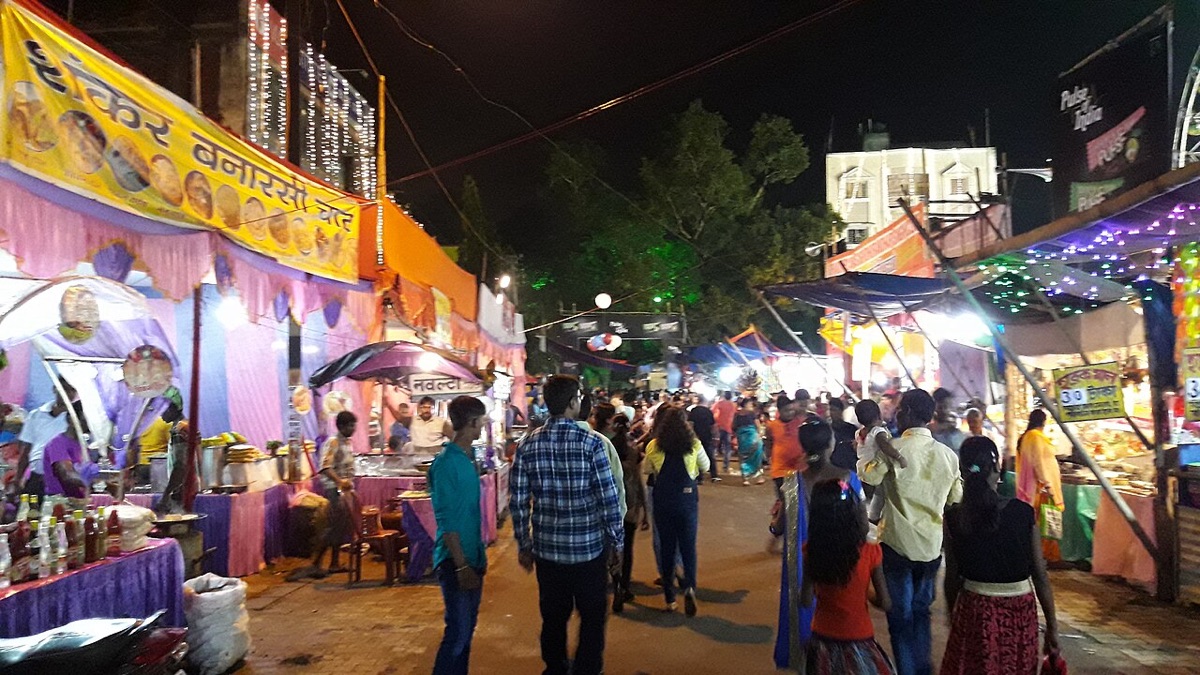 A Durga Puja fair at night in Jamshedpur, with lit food stalls on both sides of a crowded lane
